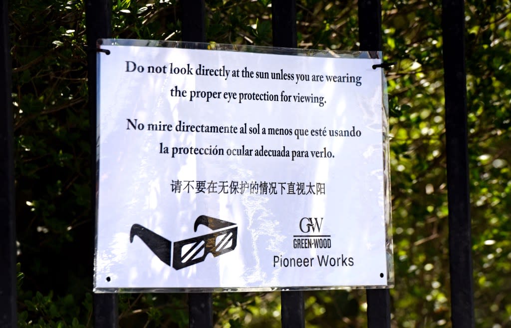 Signs warned party goers to keep their special eclipse glasses on to view the event. Gregory P. Mango