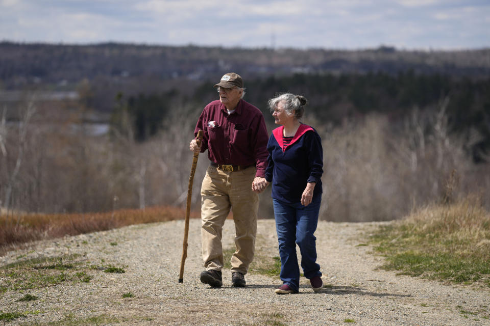 Dell and Marie Emerson walk behind their home, Thursday, April 27, 2023, in Addison, Maine. The couple is opposed to a flagpole theme park that would destroying woodlands and supplant wild blueberry barrens that have been farmed by Native Americans for 10,000 years. (AP Photo/Robert F. Bukaty)