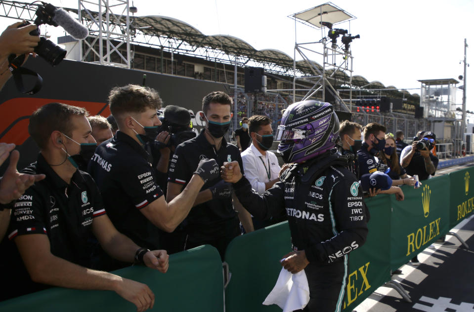 Mercedes driver Lewis Hamilton of Britain celebrates with his team after he clocked the fastest time during the qualifying session for the Hungarian Formula One Grand Prix, at the Hungaroring racetrack in Mogyorod, Hungary, Saturday, July 31, 2021. The Hungarian Formula One Grand Prix will be held on Sunday. (David W Cerny/Pool via AP)