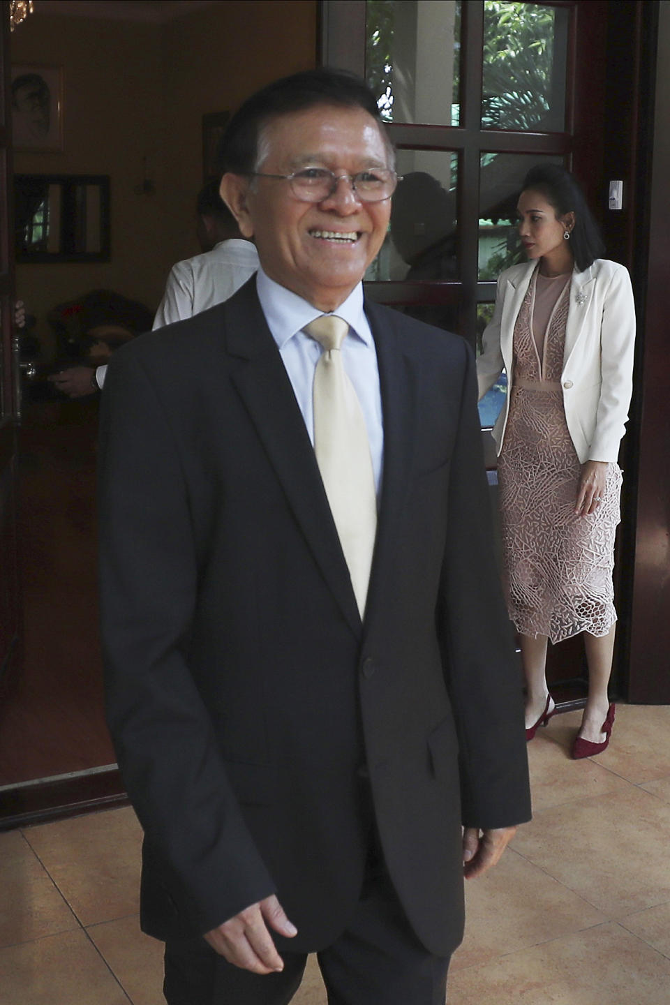 Cambodia National Rescue Party's President Kem Sokha walks to welcome French Ambassador to Cambodia Eva Nguyen Binh who arrives at his house in Phnom Penh, Cambodia, Monday, Nov. 11, 2019. A Cambodian court has lifted some restrictions on detained opposition leader Kem Sokha, essentially ending his house arrest. (AP Photo/Heng Sinith)