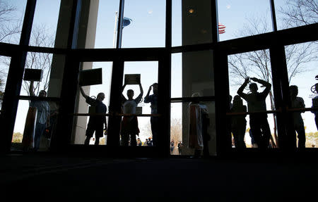 People who could not get into the event because of space limits, hold signs outside a town hall meeting for constituents hosted by U.S. Senator Tim Scott (R-SC) in North Charleston, South Carolina, U.S. February 25, 2017. REUTERS/Randall Hill