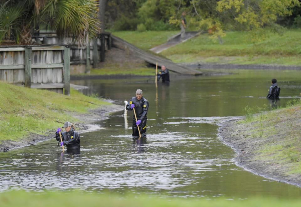 Law enforcement investigators in dry suits search the small retention pond near the entrance of the Southside Villas apartment complex off Southside Blvd. in Jacksonville, Florida Wednesday afternoon, November 6, 2019. Police in Jacksonville say Taylor Rose Williams was discovered missing from her bedroom early Wednesday. (Bob Self/The Florida Times-Union via AP)