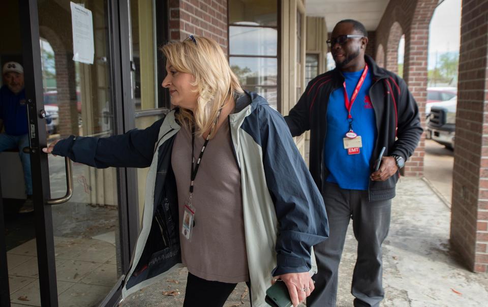 Natalie Perkins, assistant director of the Sharkey County Emergency Management Agency, left, and Kareem Harrod, operations for the county Emergency Management Service, head into the temporary emergency management headquarters in the Bearable Fitness gym in Rolling Fork on Wednesday. Perkins is also the editor of the Deer Creek Pilot, the Rolling Fork hometown newspaper. She is still publishing the paper this week.