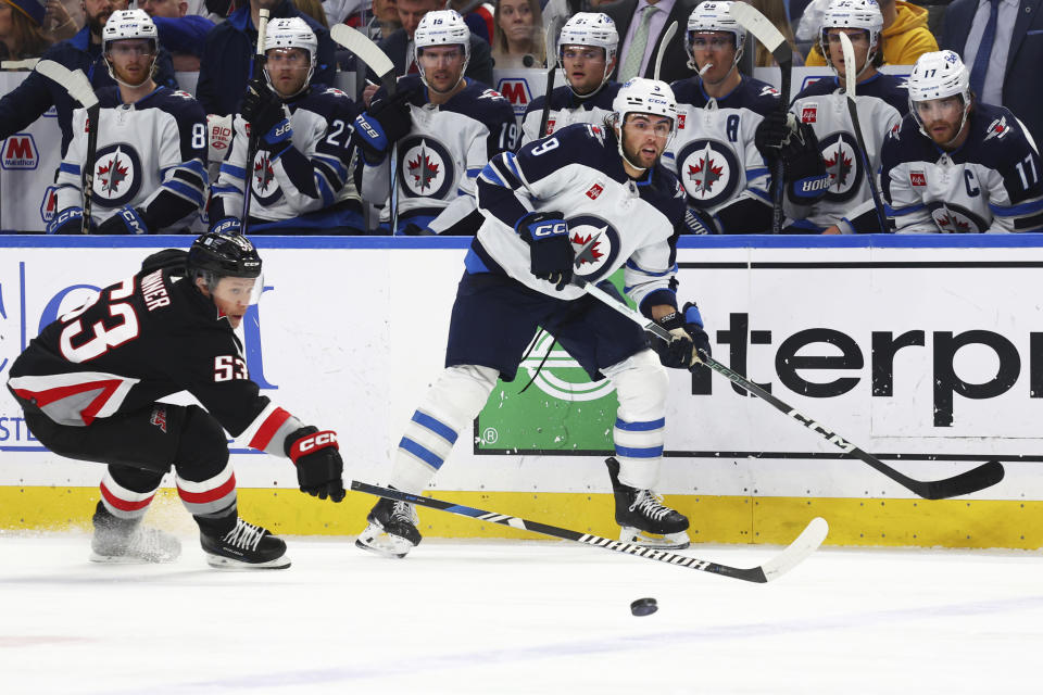 Winnipeg Jets left wing Alex Iafallo (9) passes the puck past Buffalo Sabres left wing Jeff Skinner (53) during the first period of an NHL hockey game Sunday, March 3, 2024, in Buffalo, N.Y. (AP Photo/Jeffrey T. Barnes)