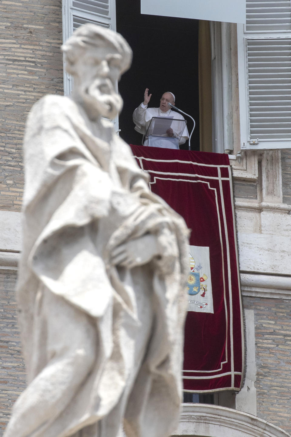 Pope Francis delivers his Angelus blessing from the window of his studio overlooking St. Peter's Square, at the Vatican, Sunday, June 14, 2020. (AP Photo/Alessandra Tarantino)