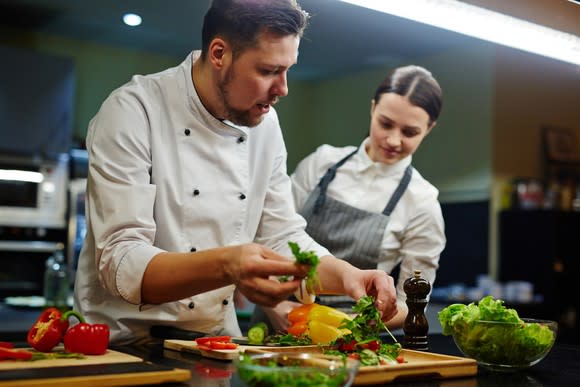 Male chef garnishing a dish