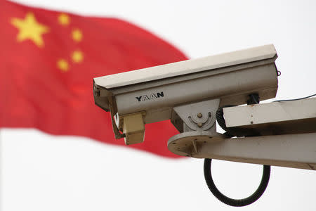 The Chinese national flag flies near a security camera on Beijing's Tiananmen Square, China May 19, 2017. REUTERS/Thomas Peter