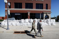 <p>Iowa National Guard members walk past a local business covered in sandbags, Monday, Sept. 26, 2016, in Cedar Rapids, Iowa. (AP Photo/Charlie Neibergall)</p>