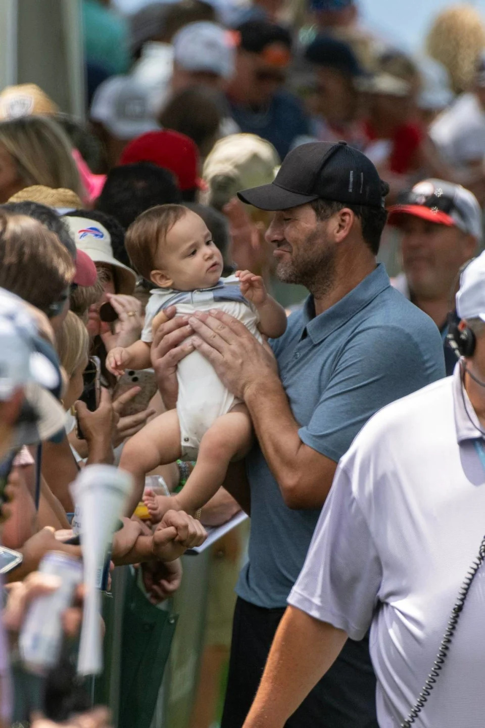 Former NFL quarterback Tony Romo poses for a photograph with a baby before reaching the 18th tee in the first round of theAmerican Century celebrity golf championship on Friday, July 12, 2024, in Stateline, Nev.