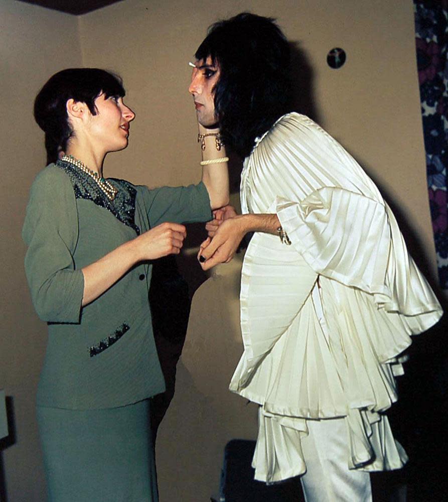 Freddie Mercury wearing a Zandra Rhodes creation with a makeup artist before going on stage at a London concert in 1974.