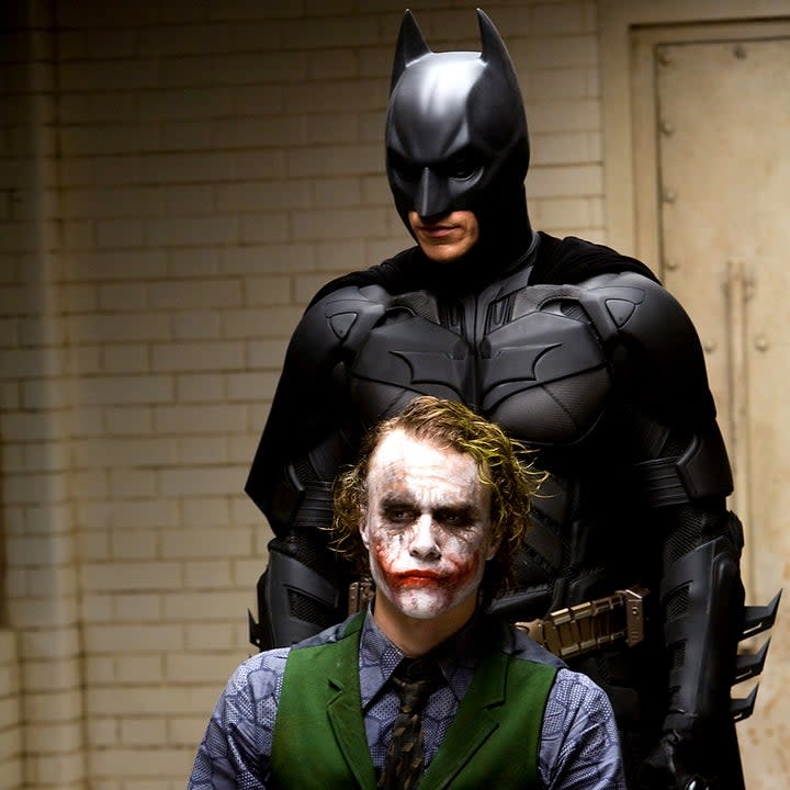 batman standing behind a seated joker