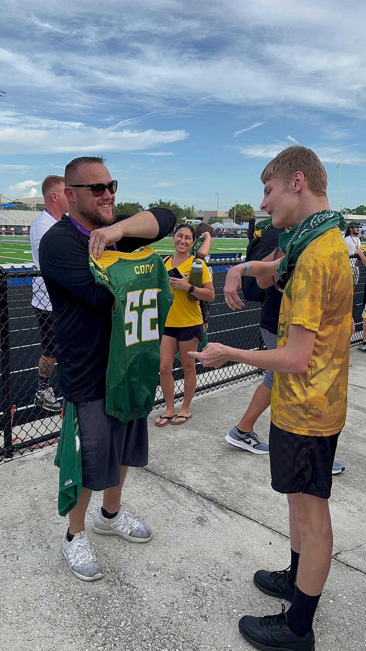 Jamie Fraser, president of the Venice Vikings Football and Cheer Organization, presents Cody with a custom Vikings jersey. "He's just always a happy, smiling face," Fraser said.