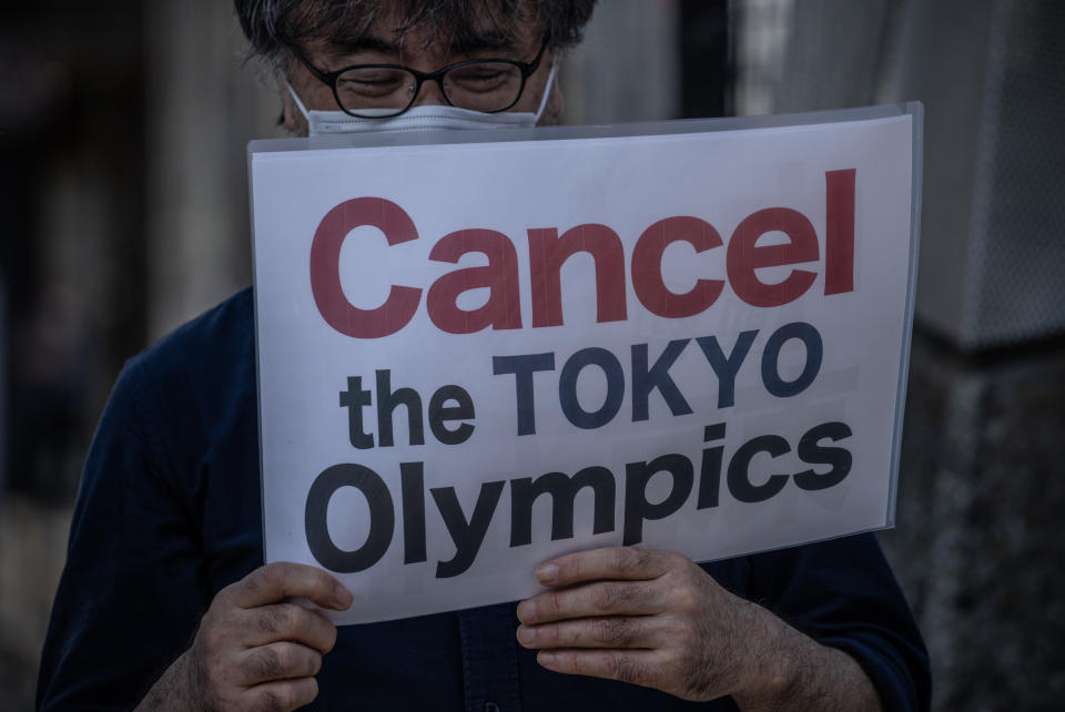 A protester holds a placard during a demonstration against the forthcoming Tokyo Olympic Games on May 23, 2021 in Tokyo, Japan.