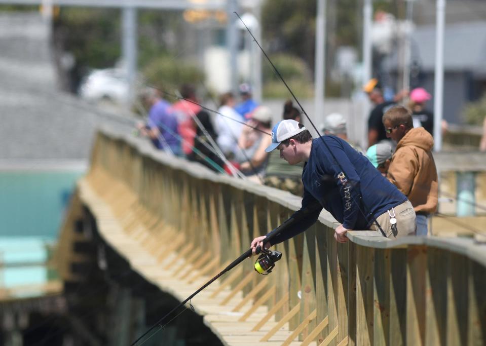 A.J. Banko fishes off the side of Kure Beach Pier in Kure Beach, N.C., Saturday, May 2, 2020.