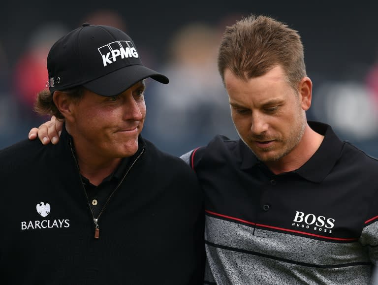 Winner Sweden's Henrik Stenson (R) consoles runner-up, US golfer Phil Mickelson on the 18th green after shooting 63 in his final round to win the Championship on day four of the 2016 British Open Golf Championship in Scotland on July 17, 2016