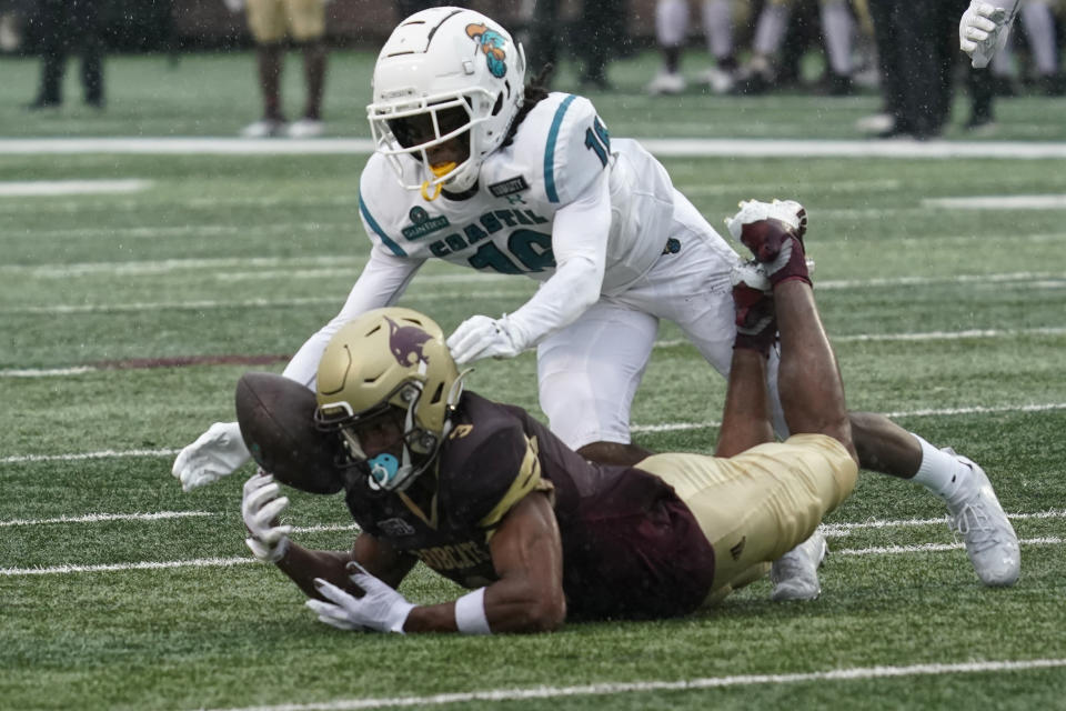 Coastal Carolina's Jordan Morris (16) reaches over Texas State's Jeremiah Haydel (3) after Haydel muffed a punt during the second half of an NCAA college football game in San Marcos, Texas, Saturday, Nov. 28, 2020. Texas State recovered the ball. (AP Photo/Chuck Burton)
