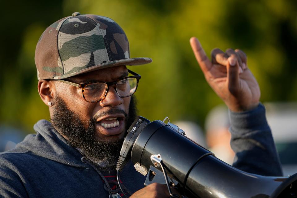 Dwayne Dunbar uses a megaphone to talk to those gathered for a recent anti-gun violence walk in Linden. Dunbar, who spent more than 13 years in prison, is the founder of a nonprofit group dedicated to assisting the incarcerated and providing youth programming to the Linden community.