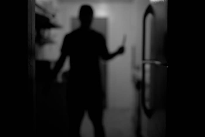 A silhouette of a person holding a knife
