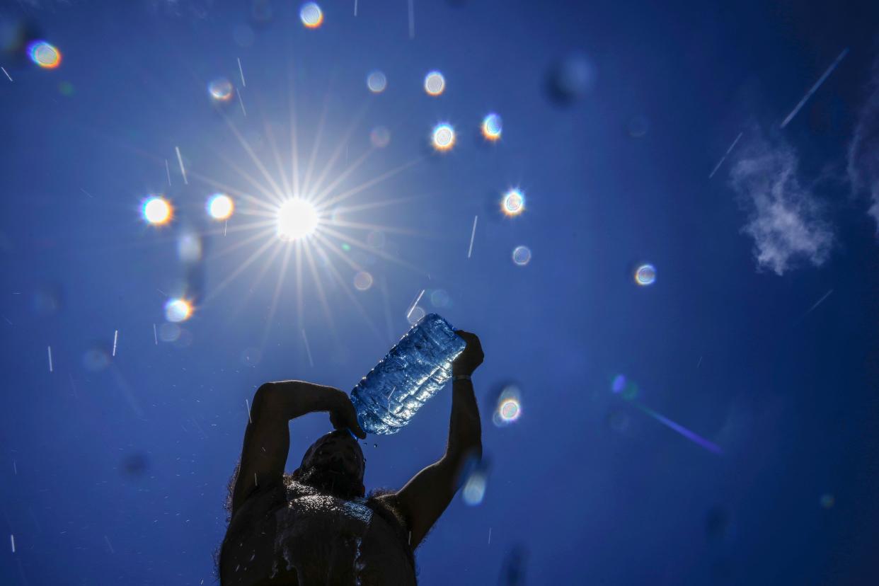 FILE - A man pours cold water onto his head to cool off on a sweltering hot day in the Mediterranean Sea in Beirut, Lebanon, July 16, 2023. European climate monitoring organization made it official: July 2023 was Earth's hottest month on record by a wide margin. (AP Photo/Hassan Ammar, File)