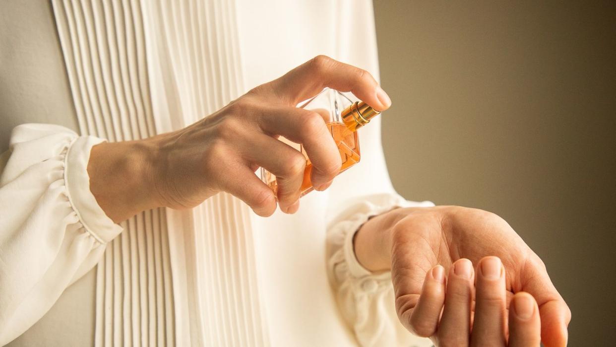 classy look of young woman applying perfume