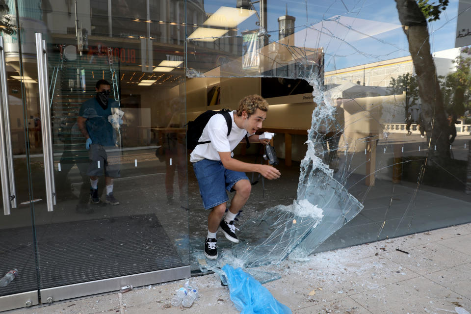 LOS ANGELES, CA -- MAY 30: Looters steal from the Appel Store at The Grove as protestors demonstrate at W 3rd St and S Fairfax Ave. in the Fairfax District on Saturday, May 30, 2020, in Los Angeles, CA. The protestors demonstrate in response to the death of George Floyd in Minnesota. Last night more than 500 arrests after looting and vandalism sweep downtown L.A. (Gary Coronado / Los Angeles Times via Getty Images)
