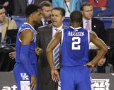 Kentucky head coach John Calipari, center, talks with guard Andrew Harrison, left, and guard Aaron Harrison during the first half of the NCAA Final Four tournament college basketball semifinal game against Wisconsin Saturday, April 5, 2014, in Arlington, Texas. (AP Photo/Tony Gutierrez)