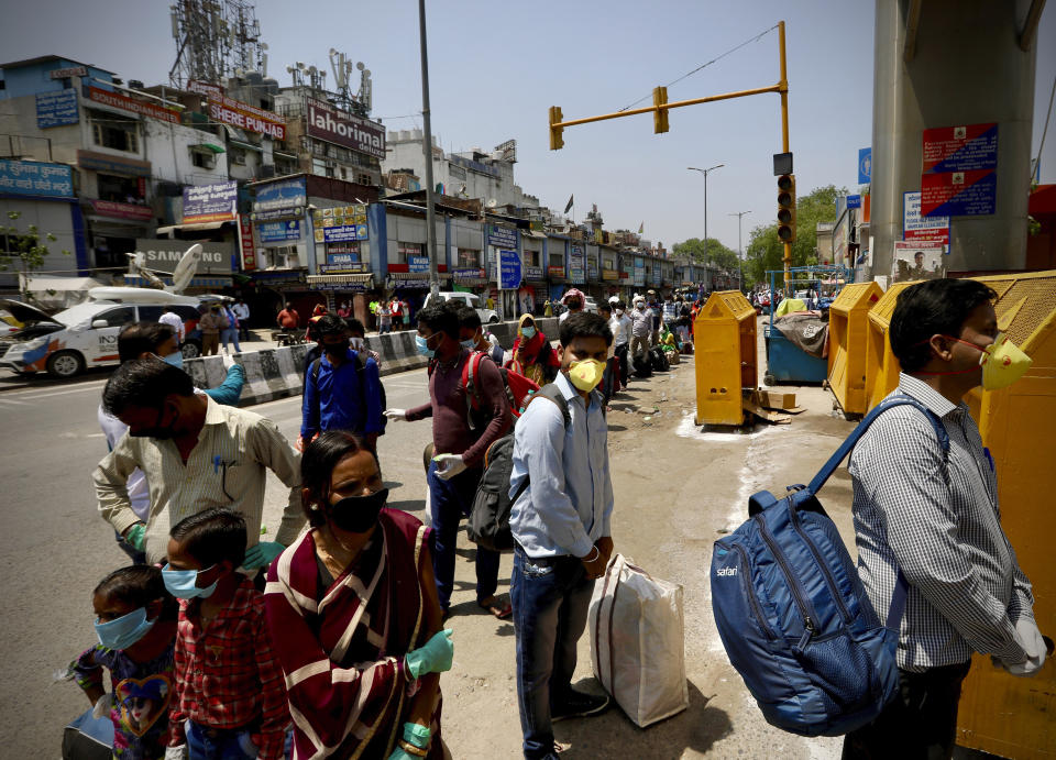 Indians line up to board trains outside New Delhi railway station in New Delhi, India, Tuesday, May 12, 2020. India is reopening some of its colossal rail network as the country looks at easing its nearly seven-week strict lockdown amid an increase in coronavirus infections. (AP Photo/Manish Swarup)