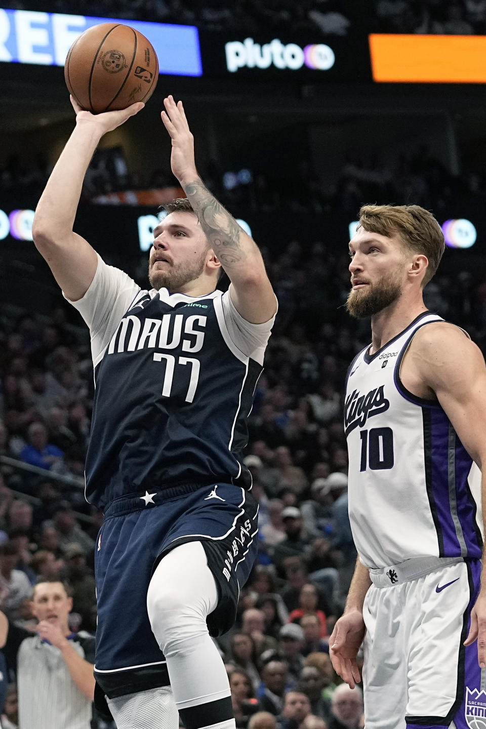 Dallas Mavericks guard Luka Doncic (77) shoots in front of Sacramento Kings forward Domantas Sabonis (10) during the first half of an NBA basketball game in Dallas, Sunday, Nov. 19, 2023. (AP Photo/LM Otero)