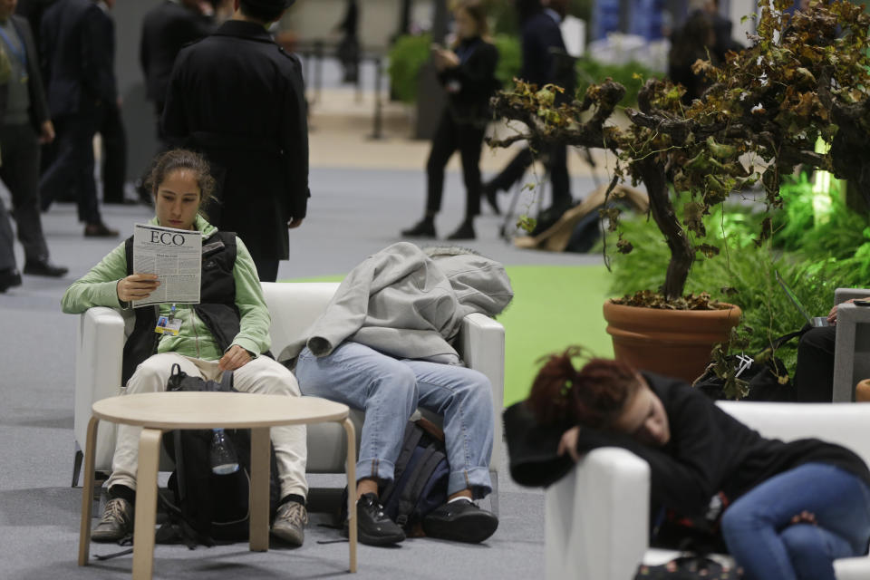 Two participants catch up with some sleep at the COP25 summit in Madrid, Spain, Tuesday, Dec. 10, 2019. The 2-week global U.N. sponsored climate change conference is taking place in Madrid. (AP Photo/Paul White)