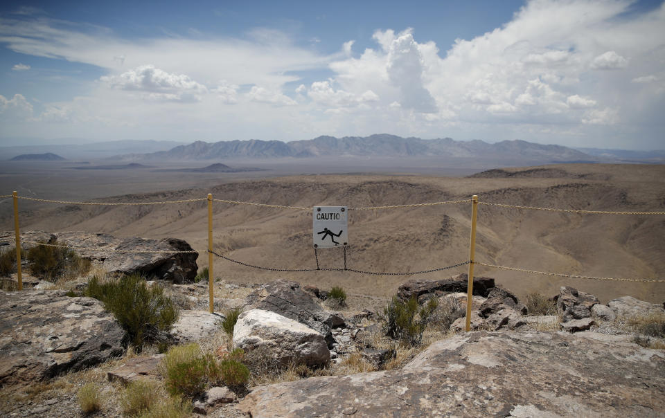 FILE - In this July 14, 2018, file photo, a sign warns of a falling danger on the crest of Yucca Mountain during a congressional tour near Mercury, Nev. Recent California earthquakes that rattled Las Vegas have shaken up arguments by proponents and opponents of a stalled federal plan to entomb nuclear waste beneath a long-studied former volcanic ridge in southern Nevada. The Las Vegas Review-Journal reports that Wyoming Republican Sen. John Barrasso said this week his legislation to jumpstart the process to open Yucca Mountain is based on studies that take seismic activity into account. Nevada officials disagree. (AP Photo/John Locher, File)