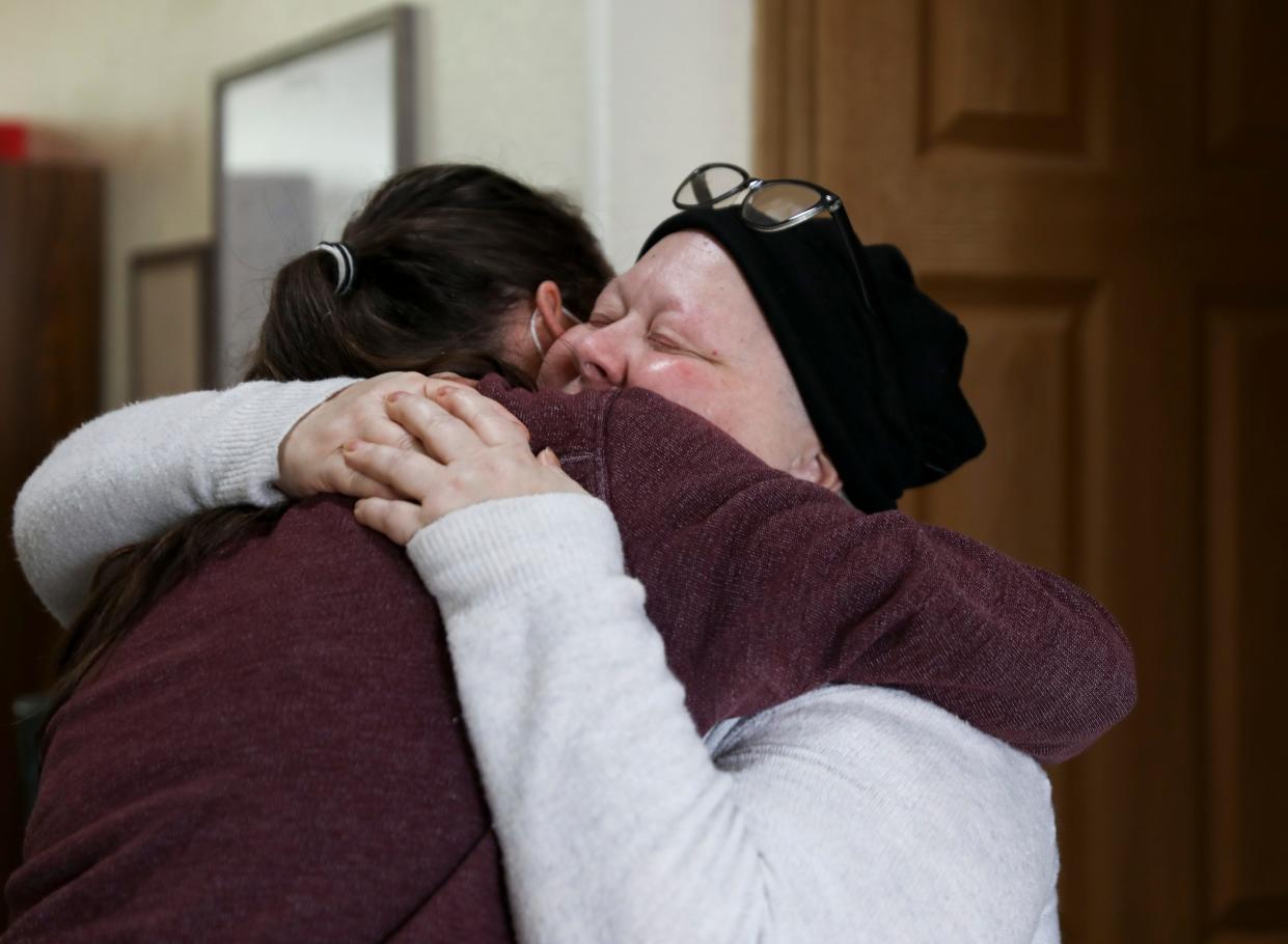 Lisa Painter hugs Andy McCandless, the founder of Michelle's Love, after her home is cleaned on Saturday in Salem. Painter, a single mom, was diagnosed with breast cancer in August 2021 and has received assistance through the non-profit.