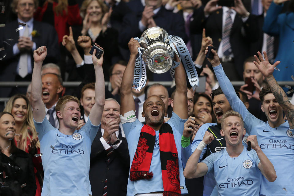 Manchester City's team captain Vincent Kompany lifts the trophy after winning the English FA Cup Final soccer match between Manchester City and Watford at Wembley stadium in London, Saturday, May 18, 2019. Manchester City won 6-0. (AP Photo/Tim Ireland)