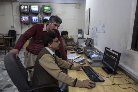 Jamshed Baghwan, the bureau chief for Express News, works in the newsroom in Peshawar November 24, 2014. REUTERS/Zohra Bensemra