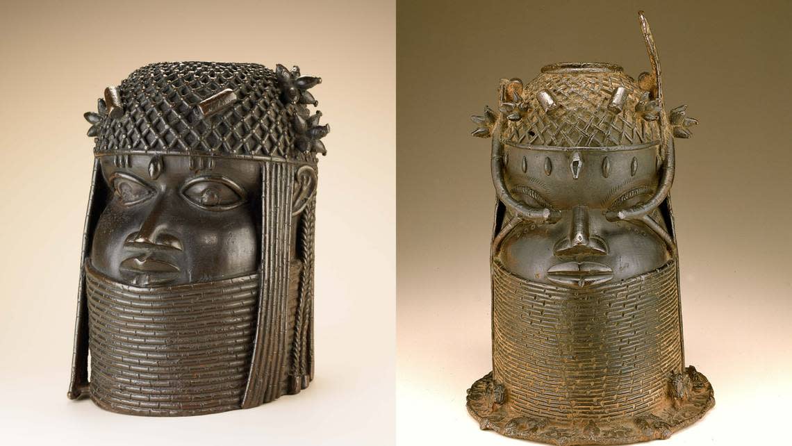 Left: A commemorative head of a king wearing a beaded collar that covers his neck up to the lower lip and a beaded cap protecting clusters and braids. Right: Another commemorative head of a king, similarly styled, with a hole on top and a wide base decorated with a leopard, mudfish, and other figures.