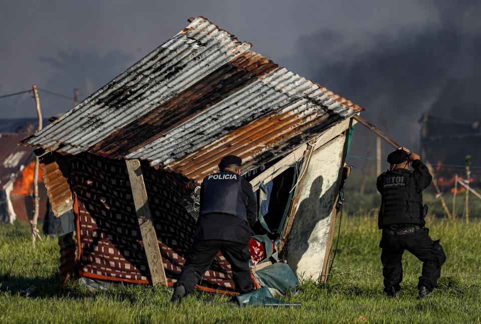 La policía destruye una casilla mientras desaloja un campamento de ocupantes ilegales en Guernica, provincia de Buenos Aires, Argentina, el jueves 29 de octubre de 2020. (AP Foto/Natacha Pisarenko)