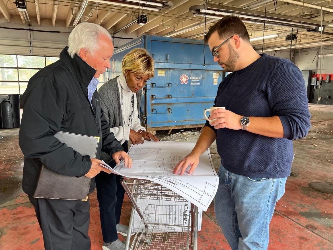 From left, Ted Swaldo, Betty Smith and Mike Scott review plans for renovations to the former Ziegler Tire building in downtown Canton. The building will become the permanent home of the EN-RICH-MENT Fine Arts Academy with support from Bluecoats. A fundraising campaign is being launched for the project.