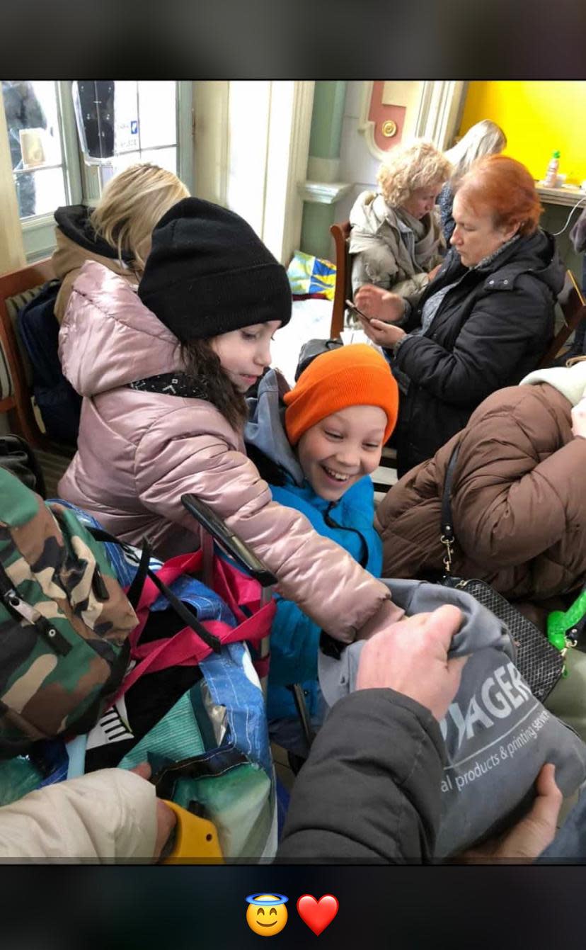 Ukrainian refugee children reach into a bag for a toy.