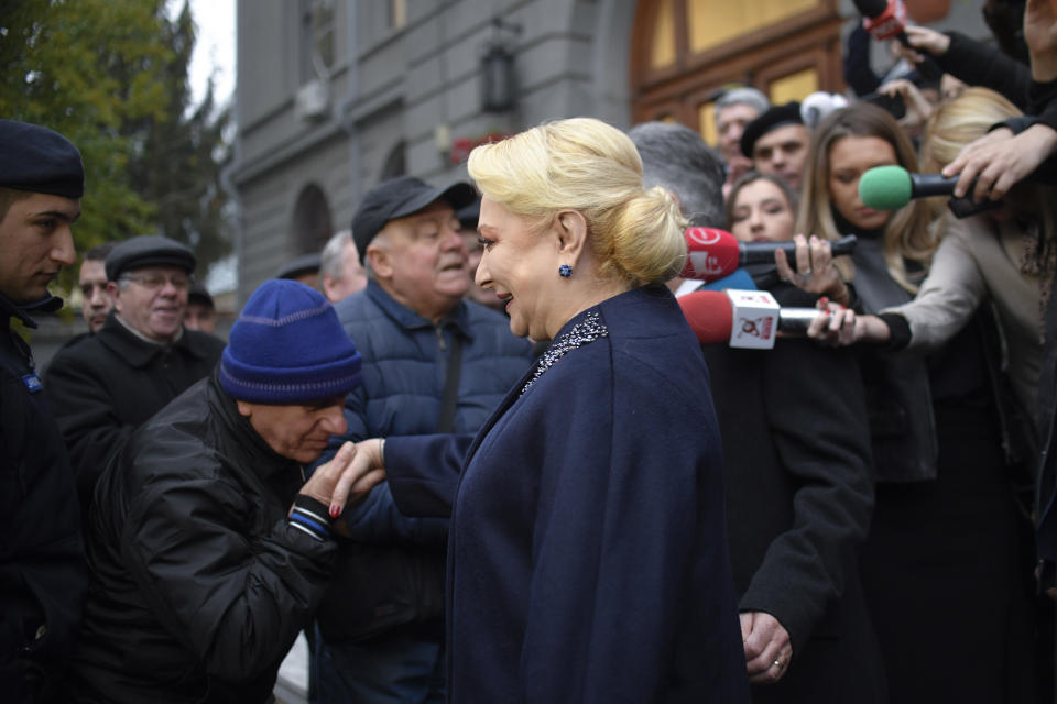 Former Prime Minister and presidential candidate for the Social Democratic party Viorica Dancila is greeted by supporters outside a voting station in Bucharest, Romania, Sunday, Nov. 24, 2019. Romanians are voting in a presidential runoff election in which incumbent Klaus Iohannis is vying for a second term. (AP Photo/Andreea Alexandru)