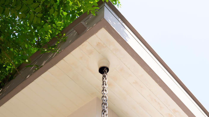 A rain chain installed in the corner of a roof
