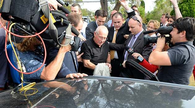 Roger Rogerson led away by police amid a media frenzy on Tuesday. Photo: AAP