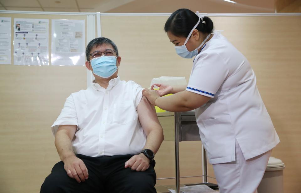 The Ministry of Health's director of medical services Kenneth Mak receiving his COVID-19 vaccination on Friday (8 January). (PHOTO: MCI)