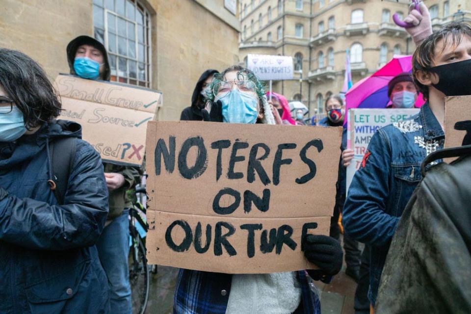A person holds a protest sign reading "No TERFs on our turf."
