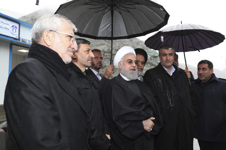In this photo released by the official website of the office of the Iranian Presidency, President Hassan Rouhani, center, speaks while visiting a new highway that connects Tehran to the north of the country, Iran, Tuesday, Feb. 25, 2020. Rouhani sought to reassure the nation in a speech on Tuesday, calling the new coronavirus an "uninvited and inauspicious passenger." "We will get through corona," Rouhani said. "We will get through the virus." (Iranian Presidency Office via AP)
