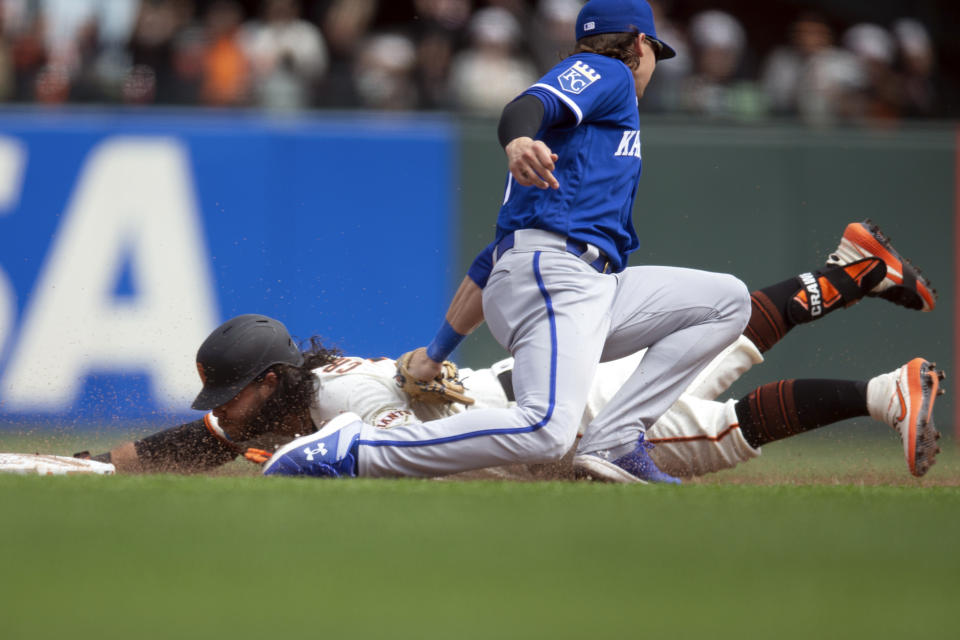 Kansas City Royals shortstop Bobby Witt Jr., top, tags out San Francisco Giants' Brandon Crawford, bottom, who was trying to stretch his RBI-single into a double during the sixth inning of a baseball game, Saturday, April 8, 2023, in San Francisco. (AP Photo/D. Ross Cameron)