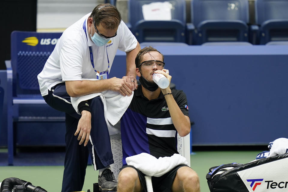 A trainer works on the shoulder of Daniil Medvedev, of Russia, during the quarterfinals of the US Open tennis championships against Andrey Rublev, of Russia, Wednesday, Sept. 9, 2020, in New York. (AP Photo/Seth Wenig)