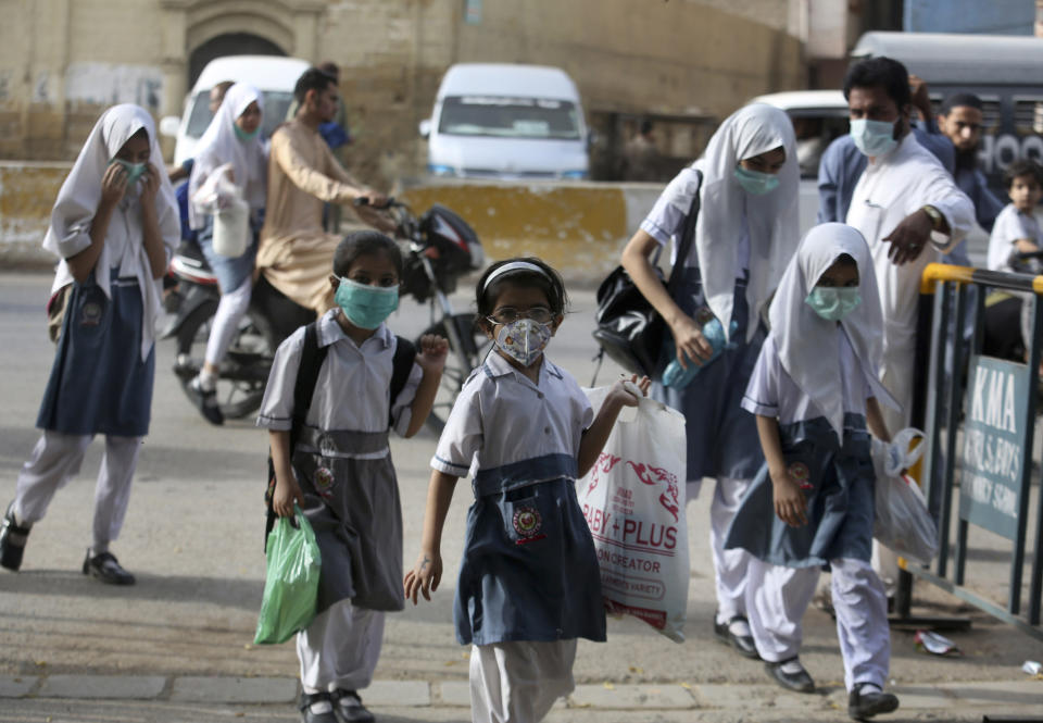 Student wearing face masks to help prevent the spread of the coronavirus arrive at a school in Karachi, Pakistan, Monday, June 21, 2021. Authorities of Pakistan's Sindh province reopened educational institutes following a steady decrease in deaths and infections from the coronavirus. (AP Photo/Fareed Khan)