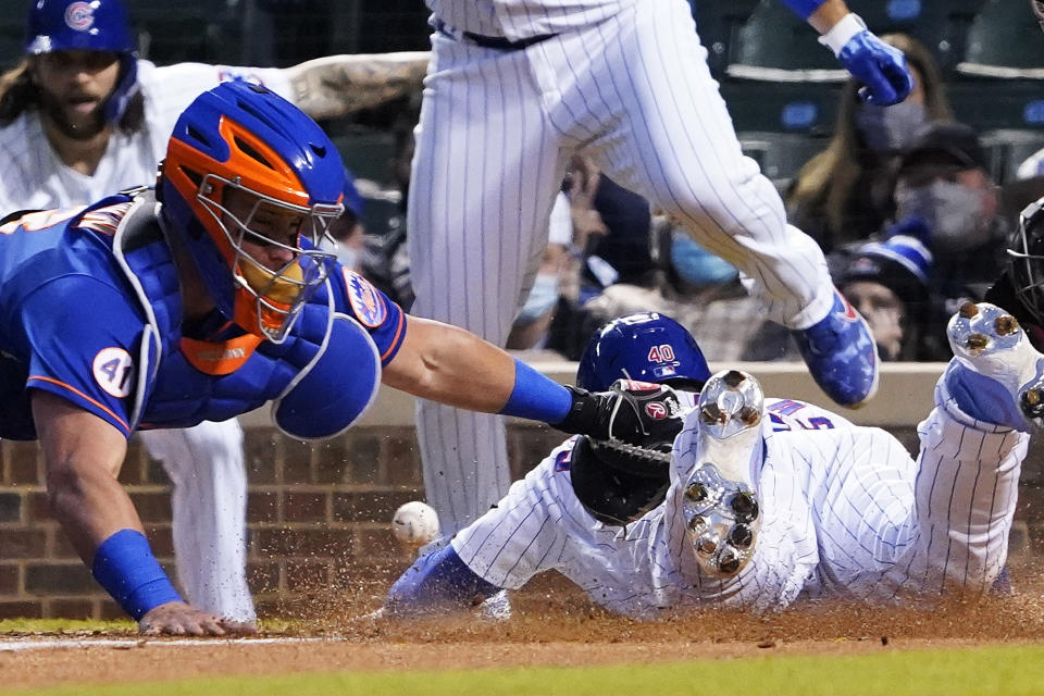 Chicago Cubs' Willson Contreras, right, is safe at home plate as New York Mets catcher James McCann, left, makes a late tag during the third inning of a baseball game, Thursday, April, 22, 2021, in Chicago. (AP Photo/David Banks)