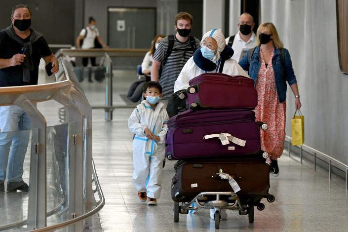 International travellers wearing personal protective equipment (PPE) arrive at Melbourne&#x002019;s Tullamarine Airport on 29 November 2021 (AFP via Getty Images)