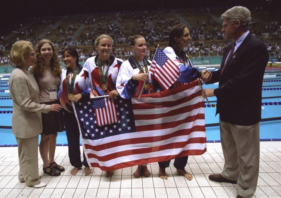 <p>The presidential family and the Olympic athletes pose together with the American flag after the 4×200 meter relay team took gold in its race. (Getty) </p>