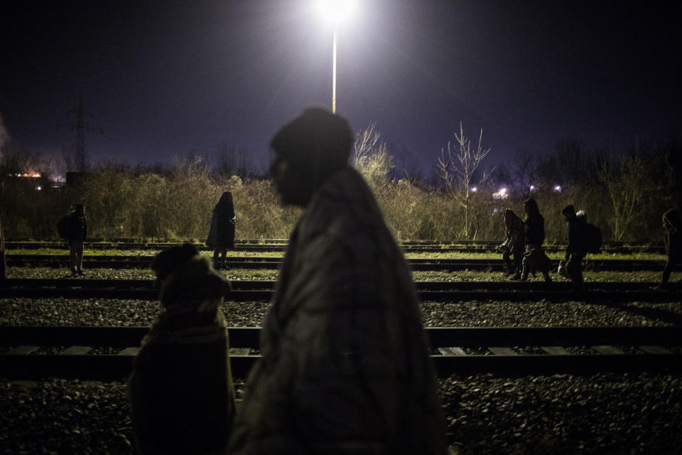 A group of migrants wander around the rail tracks near the river Drina bordering between Bosnia and Serbia in the town of Karakaj, northeastern Bosnia on Dec. 17, 2019. (Photo: Manu Brabo/AP)